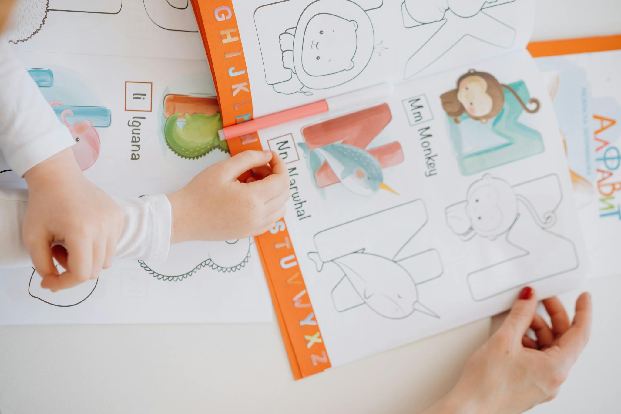 Children engage in learning the alphabet using a coloring book with bright illustrations.